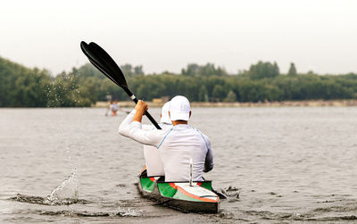 Rear view of man on boat in river