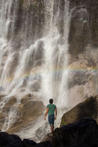 Woman swimming in waterfall