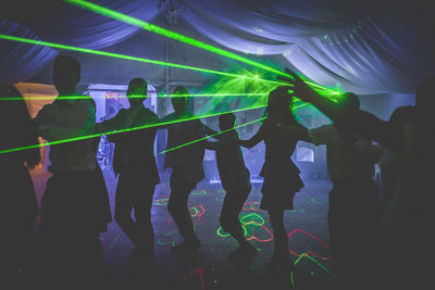 Group of people dancing in nightclub during party