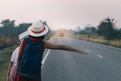 Women hitchhiking on road