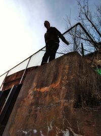 Low angle view of man standing against wall