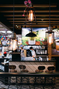 Illuminated lanterns hanging in store for sale