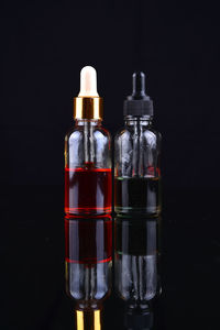 Close-up of glass bottle on table against black background