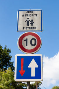 Low angle view of road sign against blue sky