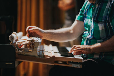 Midsection of man playing piano