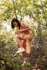 Woman standing amidst plants in forest