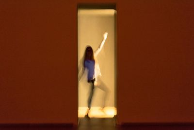 Woman standing by wall