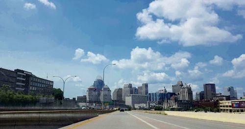 Buildings in city against cloudy sky