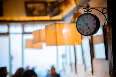 Low angle view of clock hanging on wall in building