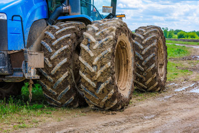 Dirty double wheels of agriculture tractor at summer day