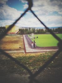 Scenic view of field seen through chainlink fence