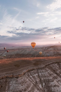 Hot air balloons flying over landscape against sky