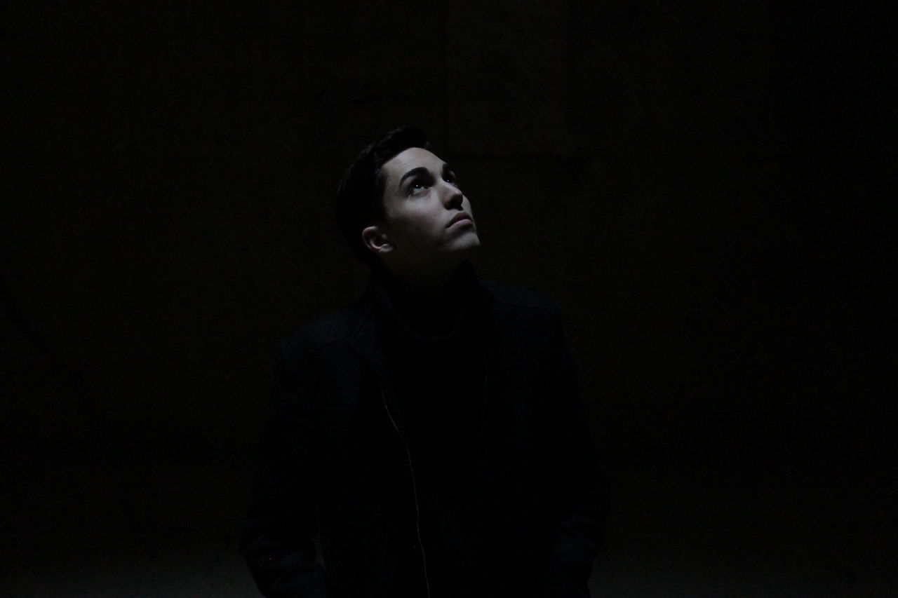 PORTRAIT OF YOUNG MAN LOOKING AWAY OVER WHITE BACKGROUND