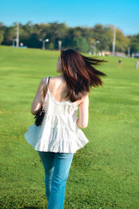 Rear view of woman standing on field