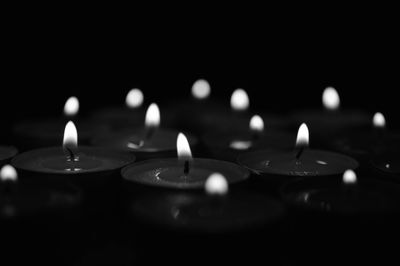 Close-up of lit candle in dark room