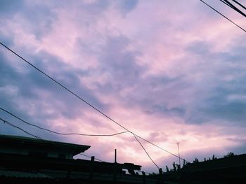 Low angle view of cables against dramatic sky