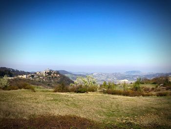 Scenic view of field against clear blue sky