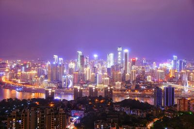 Illuminated cityscape against sky at night