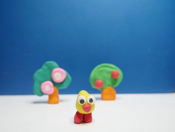 Close-up of clay toys against blue background