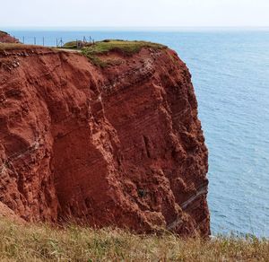 Rock formations by sea against sky