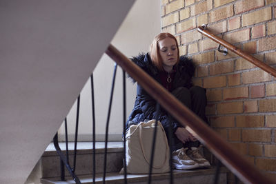 Young woman sitting on stairs