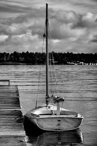 Sailboats moored on sea against sky