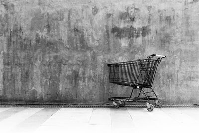 Abandoned shopping cart against wall