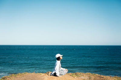 Man looking at sea against clear sky