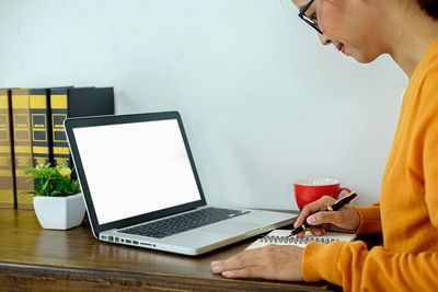 Low angle view of woman using laptop on table