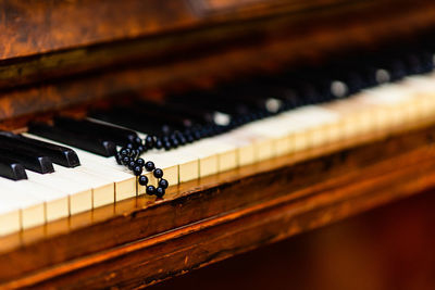 Close-up of bead necklace on piano keys