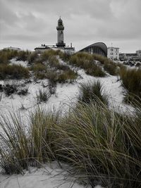 Lighthouse by sea against sky