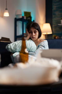 Portrait of young woman sitting on bed at home