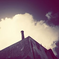 Low angle view of building against cloudy sky