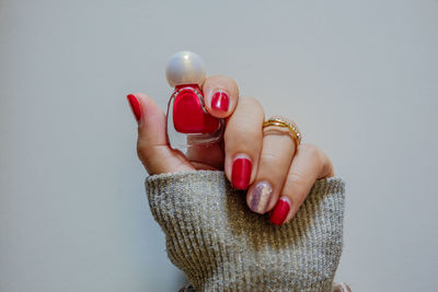 Close-up of woman holding heart shape over white background