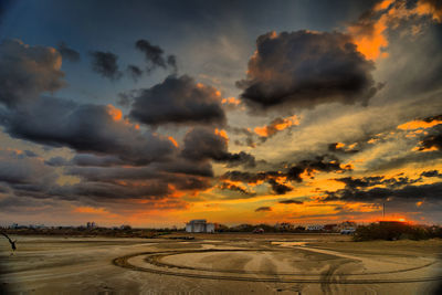 Scenic view of dramatic sky over beach during sunset