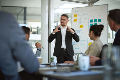 A businessman having a meeting in the boardroom with his team. a mature leader giving a presentation