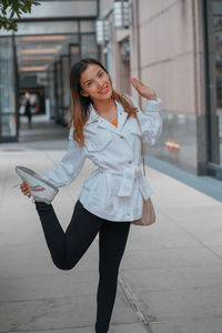 Portrait of young woman standing in city