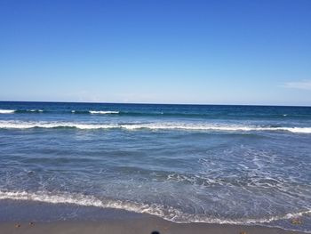 Scenic view of sea against blue sky