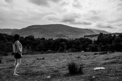 Woman looking away while standing on land