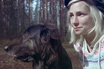 Close-up of woman with dog in forest
