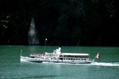 Boat sailing on sea against trees