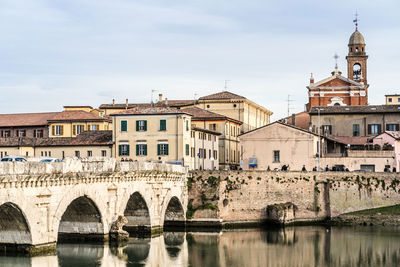 Bridge over river against buildings in city