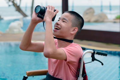 Smiling boy looking through camera