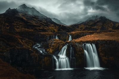 Scenic view of waterfall against sky
