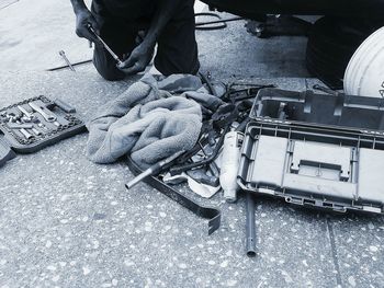 High angle view of mechanic kneeling on floor with tools