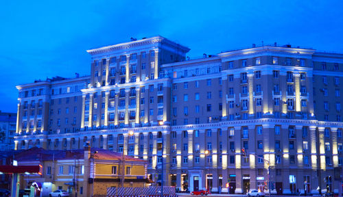 Low angle view of illuminated building against blue sky