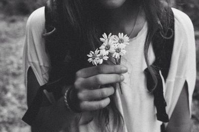 Cropped image of girl holding flowers