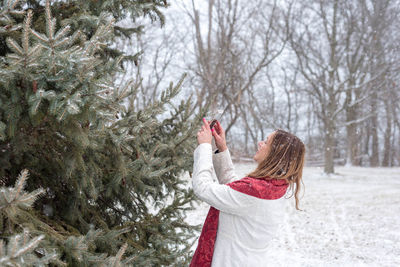 Woman with christmas tree in snow