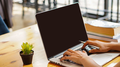 Midsection of man using laptop on table