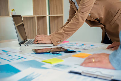 Close-up of woman using laptop on table